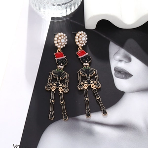 Detail of Halloween skull earrings with red hats, green bowties and pearl studs