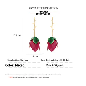 Detail view of floral drop earrings with red enamel buds and green leaves measuring 10.6cm