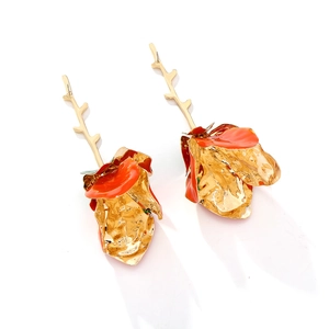 Detail of layered gold metal flower earrings with vibrant orange enamel petals