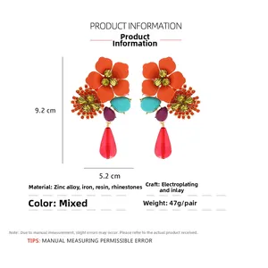 Detailed macro view of bohemian tiered floral earrings with colorful crystals and resin