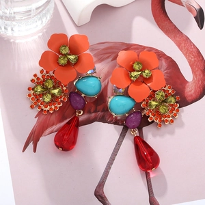 Close-up of Bohemian tiered flower earrings with colorful crystals and red teardrops