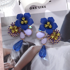 Detail of bohemian layered flower earrings with blue petals and colorful crystals