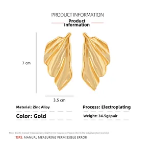 Detail view of large gold leaf earrings showing 7cm height and 3.5cm width dimensions