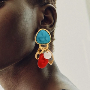 Vintage turquoise shell tassel earrings with red organic charms worn by a model