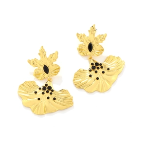 Detailed macro shot of vintage gold flower earrings with black stones and hammered texture