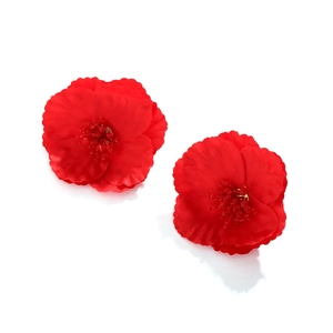 Détail macro de boucles d'oreilles fleurs en tissu rouge avec cœur perlé en cristal