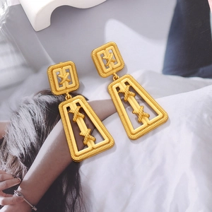 Detailed macro view of vintage gold geometric trapezoid earrings with matte brushed finish