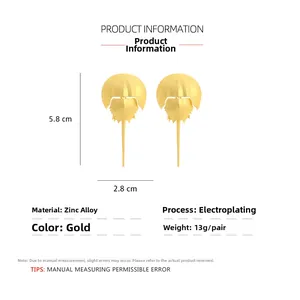 Macro detail of golden horseshoe crab earrings with size dimensions and zinc alloy texture