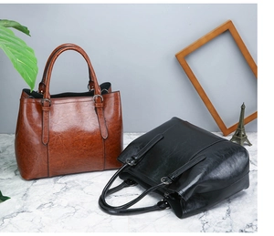 Detailed view of large capacity glossy leather handbags in vintage brown and classic black