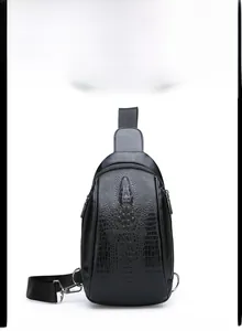 Detail shot of men's black crossbody chest bag featuring embossed crocodile pattern