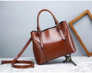 Detail of caramel brown glossy patent leather tote bag with vertical stitching