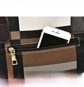 Detail of checkered bag back zipper pocket showing capacity with a smartphone inside
