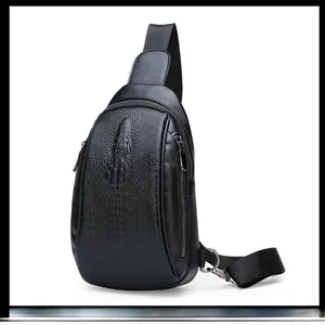 Macro detail of men's black crossbody bag with embossed crocodile texture and metallic zip