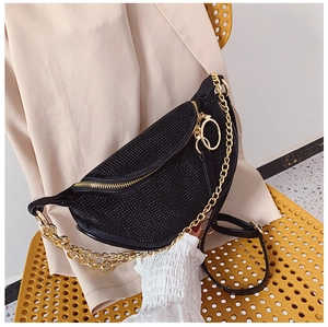 Macro detail of black rhinestone handbag with thick gold chain and zip closure