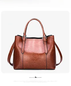 Front view of brown patent leather tote bag with pebble texture and silver hardware