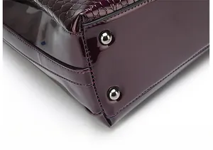 Detail of purple crocodile embossed leather handbag base with metal protective feet