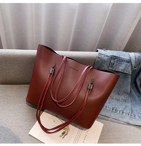 Deep burgundy tote bag detail with white contrast stitching and Forever Young print