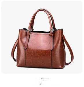 Side view of large brown oil wax leather tote bag with silver hardware and shoulder strap