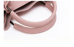 Close-up of pink leather handbag showing fine texture and dark metal hardware details