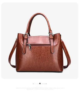 Detailed back view of brown patent leather tote bag with functional silver zipper pocket