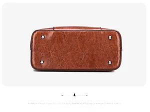 Detail view of the brown patent leather tote base with protective silver metal feet