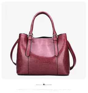 Detail of red patent leather tote bag with glossy finish and metal ring hardware