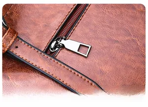 Detail showing high-quality metal zipper and precision stitching on brown oil wax leather bag