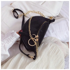 Close-up of black crescent bag with sparkling rhinestones and gold chain details
