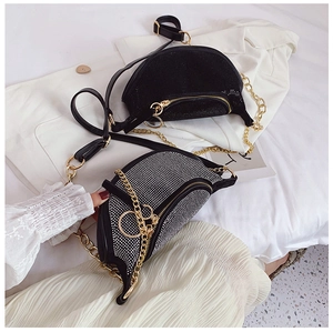 Close-up of sparkling rhinestone moon bag with golden chain and adjustable strap