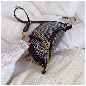 Detail of black crescent rhinestone bag with golden D charm and metallic chain strap