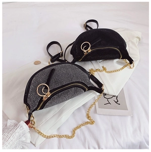 Detailed view of two rhinestone crescent waist bags with gold chain and ring zipper