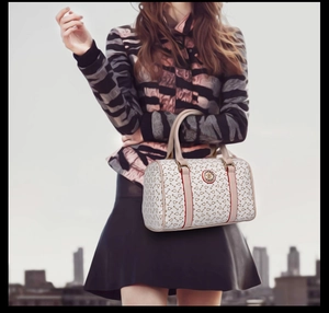 Close-up of the monogram print and gold logo on a stylish Boston handbag with double handles