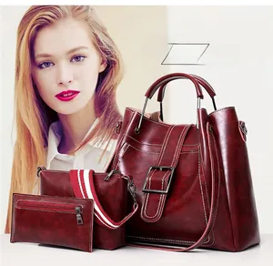 Three-piece burgundy faux leather handbag set featuring contrast stitching and striped strap