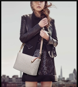 Close-up of anchor monogram crossbody bag with gold lock and slim leather strap