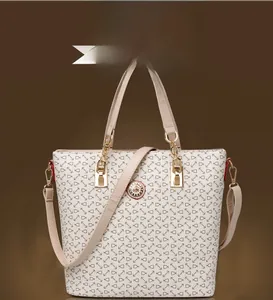 Front view of white tote bag with anchor print and golden metal emblem detailing