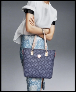 Detail of navy blue tote bag with white anchor patterns and pink leather handles