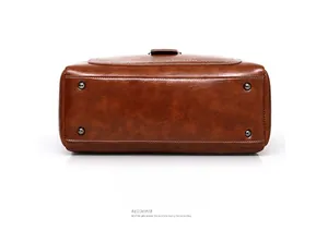 Brown leather handbag bottom view featuring four protective metal feet and fine stitching