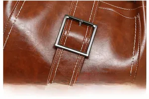 Macro view of brown lychee grain leather with white stitching and metal buckle detail