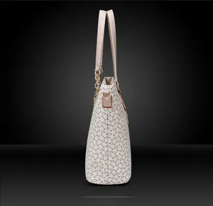 Positive side view of white tote bag with geometric print and red oil edge detail