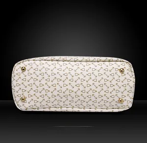 Close-up of bag bottom with golden metal feet and anchor print on white leather