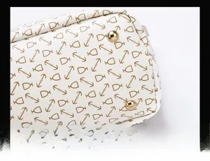 Macro detail of bottom metal studs on printed white leather handbag for wear resistance