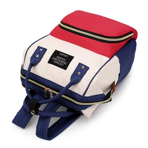 Three-color canvas backpack in red white and blue with gold zippers and top handles