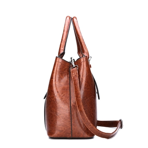 Brown glossy patent leather tote bag with sturdy handles and adjustable shoulder strap
