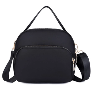 Waterproof black nylon crossbody bag with gold zippers and adjustable strap shown on white background