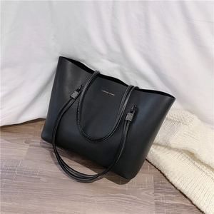 Minimalist large black leather tote bag with white contrast stitching for daily use