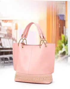 Detailansicht der rosa Ledertasche mit goldenen Nieten und Kettenhandgriffen