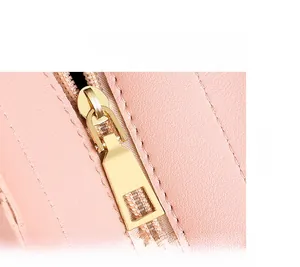 Detailansicht der rosa Ledertasche mit Narbenstruktur und hellem Goldreißverschluss