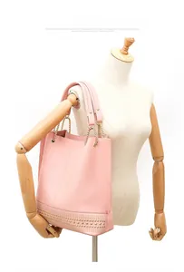 Rosafarbene Shopper-Tasche aus Kunstleder mit Goldnieten an einer Schaufensterpuppe