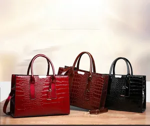 Detailansicht der Krokodil-Prägung Handtaschen in Rot, Braun und Schwarz mit Metallteilen