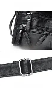 Détail du cuir grainé noir avec fermetures éclair argentées et boucle de réglage en métal